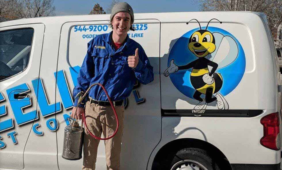 Smiling pest control worker with equipment gives thumbs-up next to a van with bee mascot.